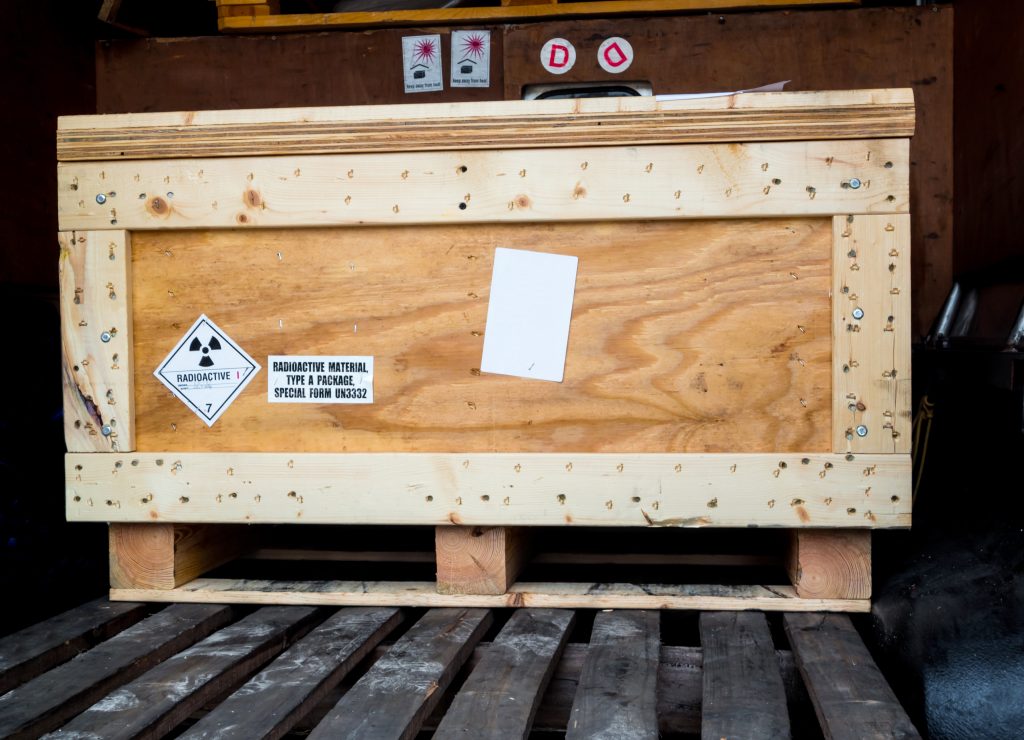 Radiation warning sign transport label Class 7 on the Dangerous goods package type A in the container of transport truck wooden shipping crate labeled radioactive